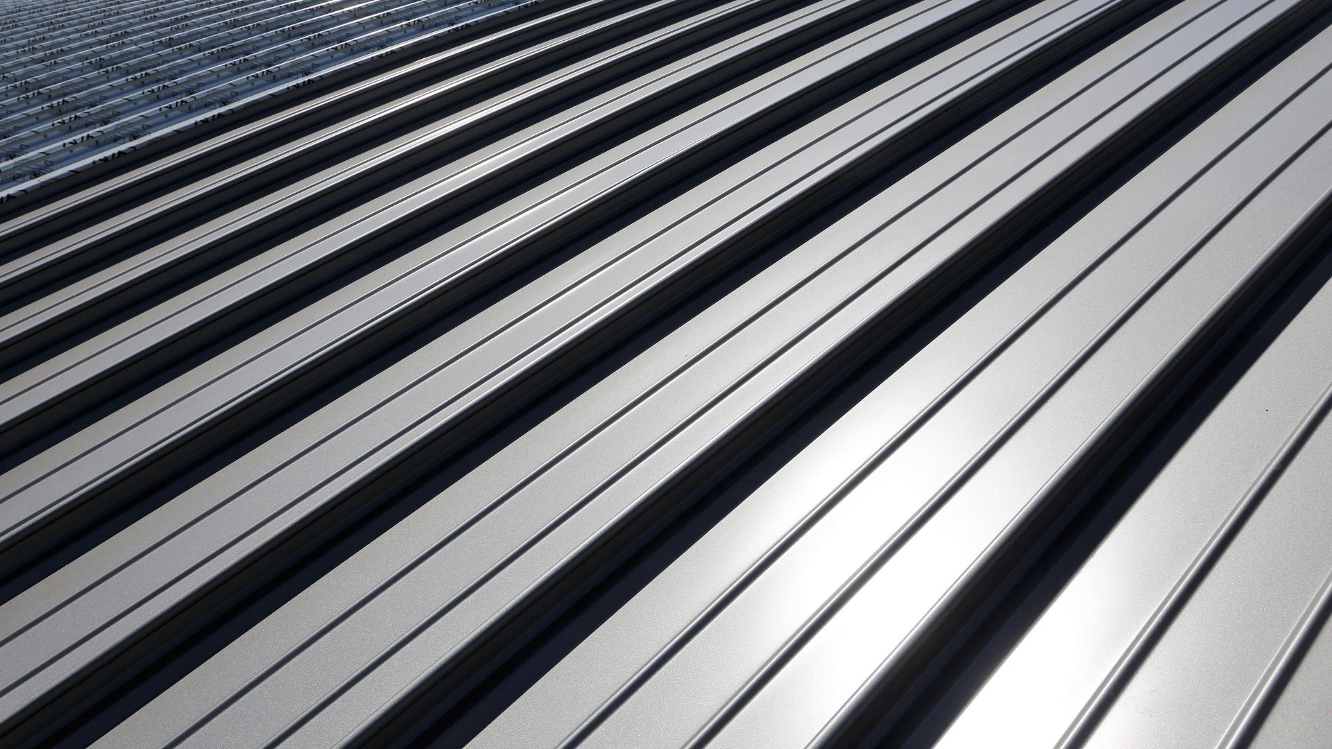 A close up of a metal roof with a building in the background