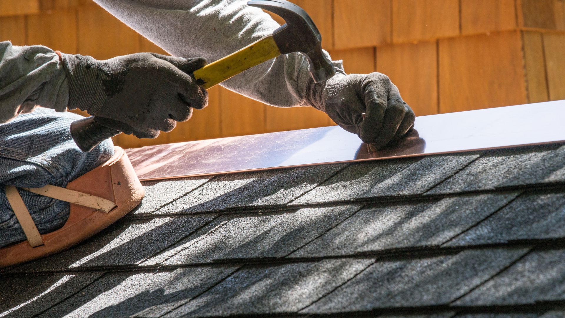 A man working on a roof with a hammer